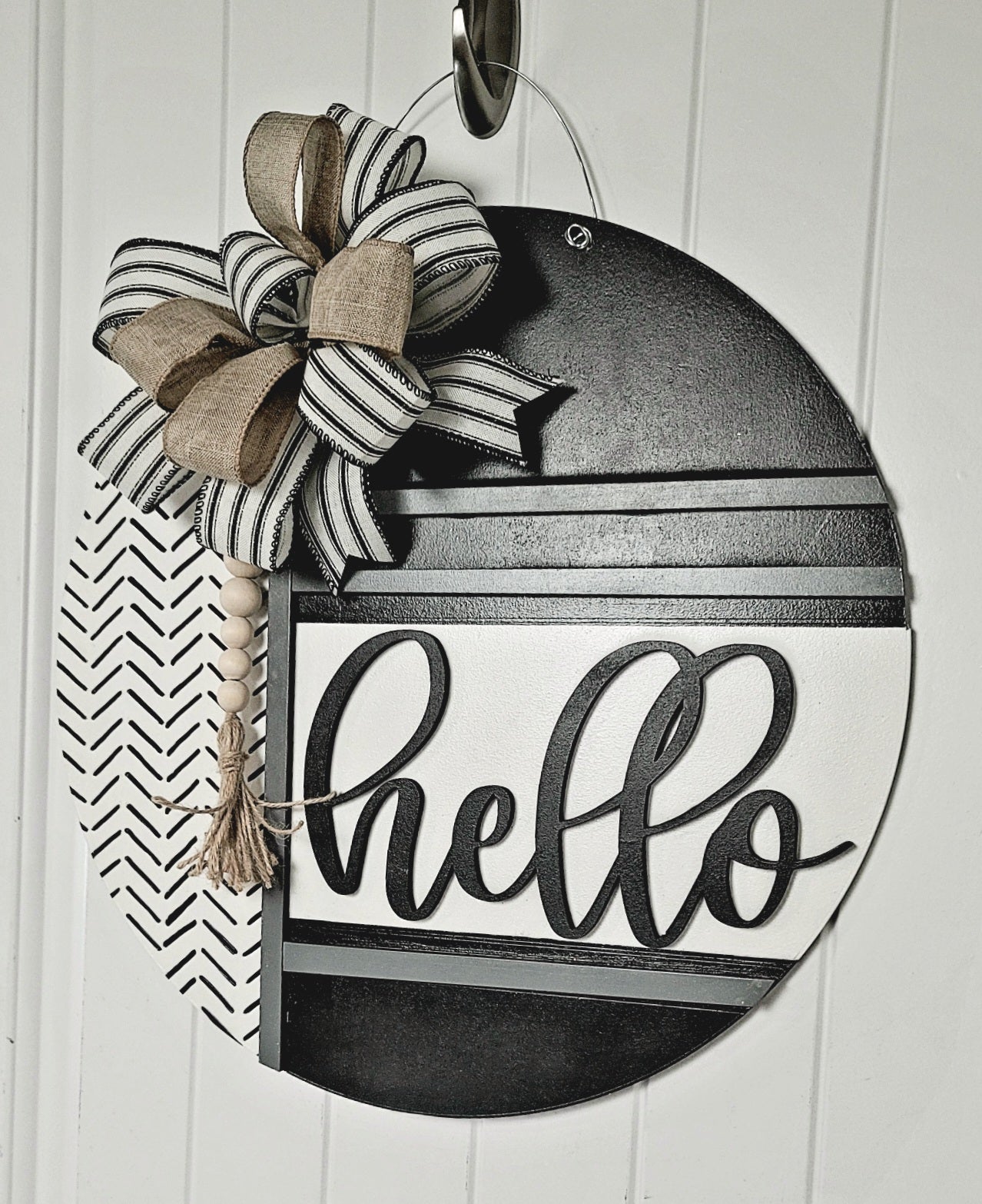 Handmade black and white round wooden "Hello" door sign featuring modern farmhouse design, striped and burlap bow, wood bead tassel, and chevron pattern – perfect for front door, porch, or entryway decor.
